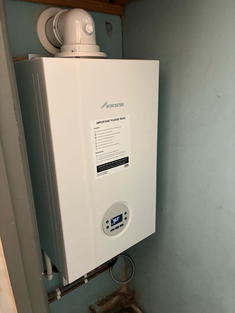 White Worcester Bosch combi boiler installed neatly on a light blue painted wall